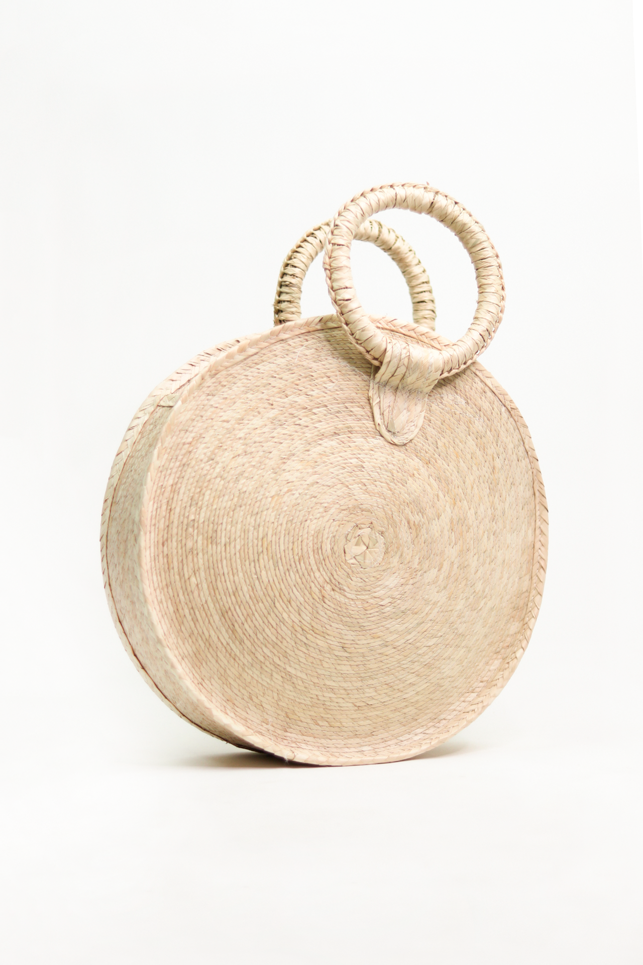 round woven handbag with a round handle to hold it, made from dried palm leaves.
